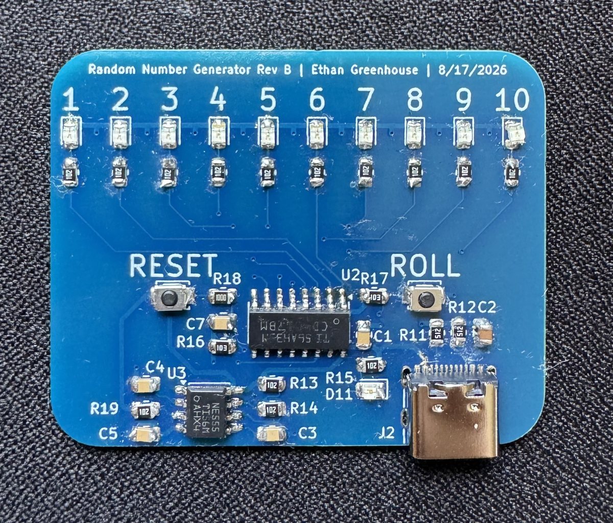 Assembled Rev B random number generator board with ten numbered LEDs, the CD4017 and NE555, RESET and ROLL buttons, and an edge mounted USB-C connector